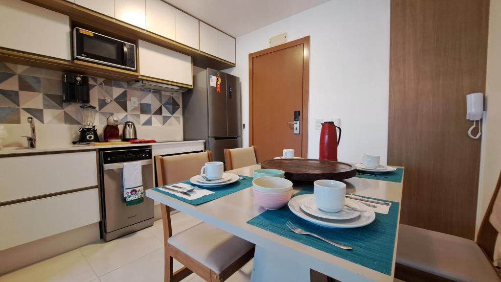 a kitchen with a table with dishes on it at Athos Bulcão - Cobertura Duplex - Un 1519 in Brasilia