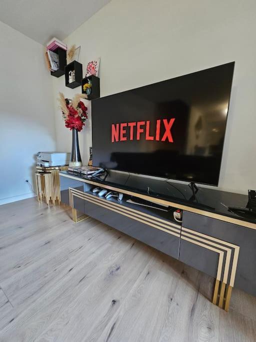 - un salon avec une télévision connectée sur un mur dans l'établissement Maison avec jardin proche gare, à Belleville-en-Beaujolais
