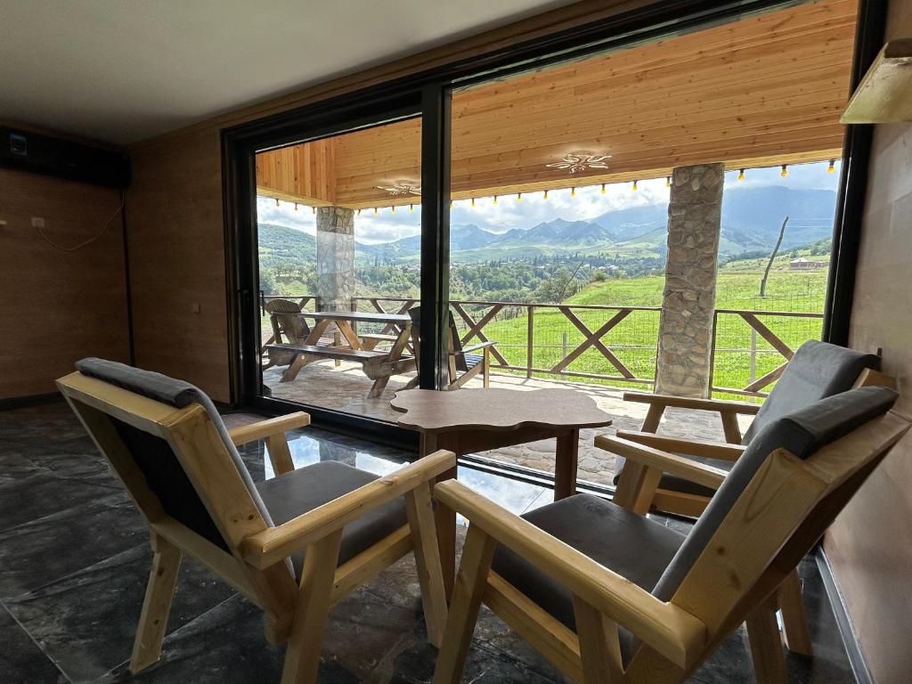 a room with two chairs and a table and a large window at Shahdag Nature House in Qusar