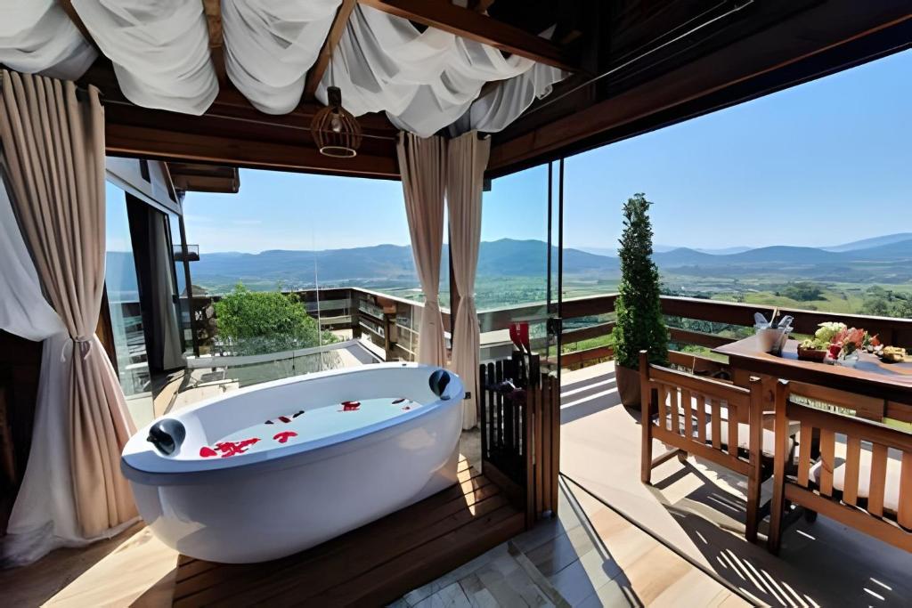 a bathroom with a bath tub on a balcony at Chalé da Montanha com Ofurô in Santo Amaro da Imperatriz