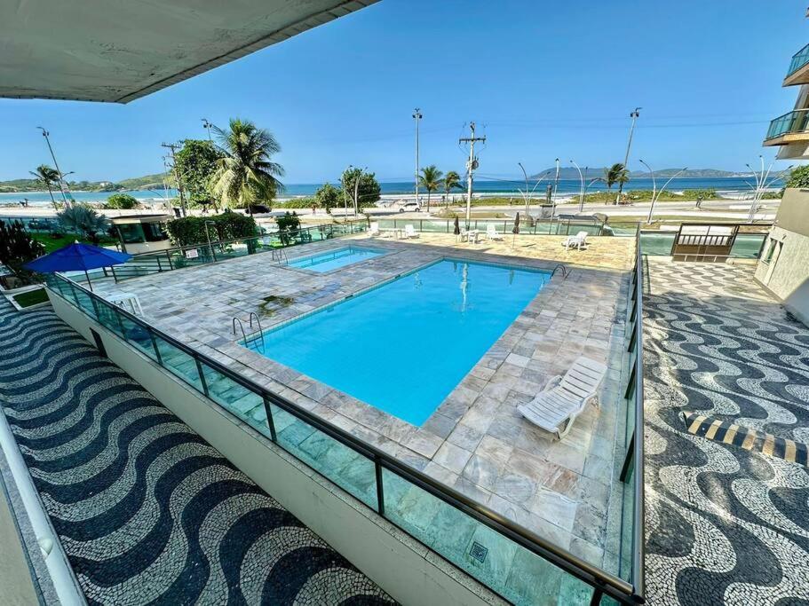 una piscina sul balcone di un resort di Ap Alecrim Praia do Forte Cabo Frio Pé na Areia3qt a Cabo Frio