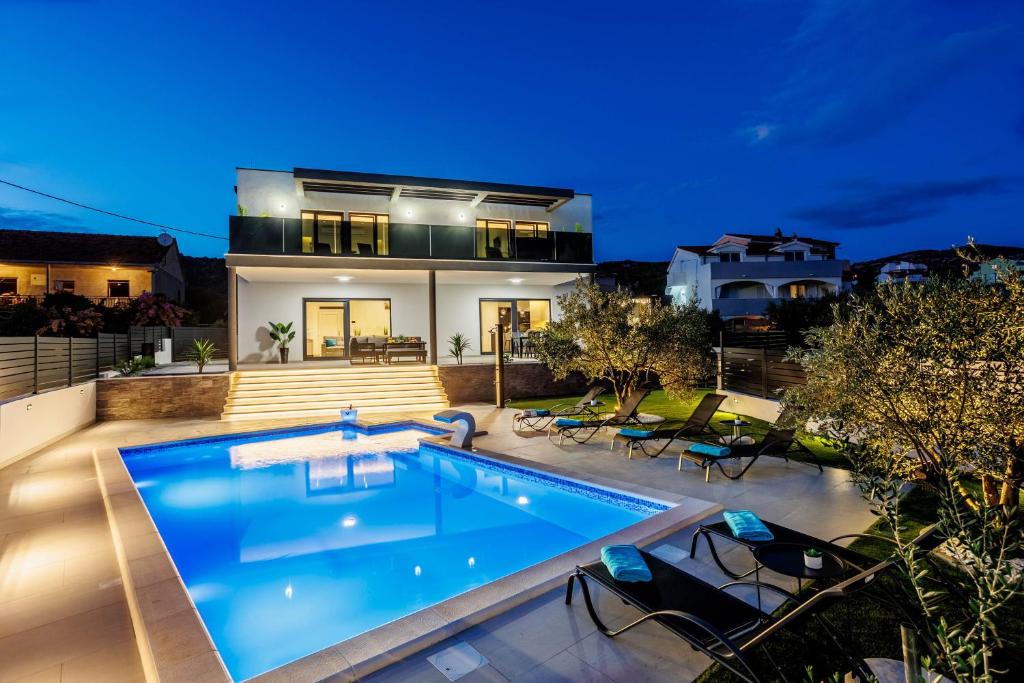 ein Haus mit Swimmingpool bei Nacht in der Unterkunft Villa dal' Mares in Vinišće