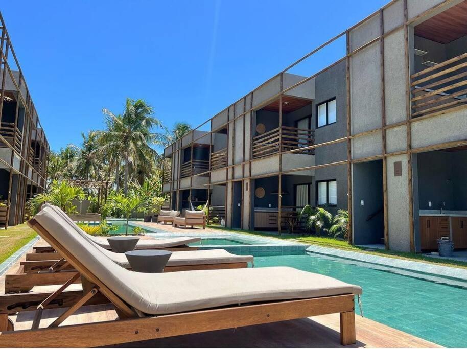 a resort with a swimming pool and a building at Villa Kamby Milagres B003 in São Miguel dos Milagres