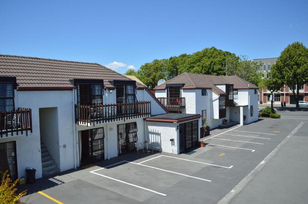 a parking lot with a row of buildings at Southern Comfort Motel in Christchurch