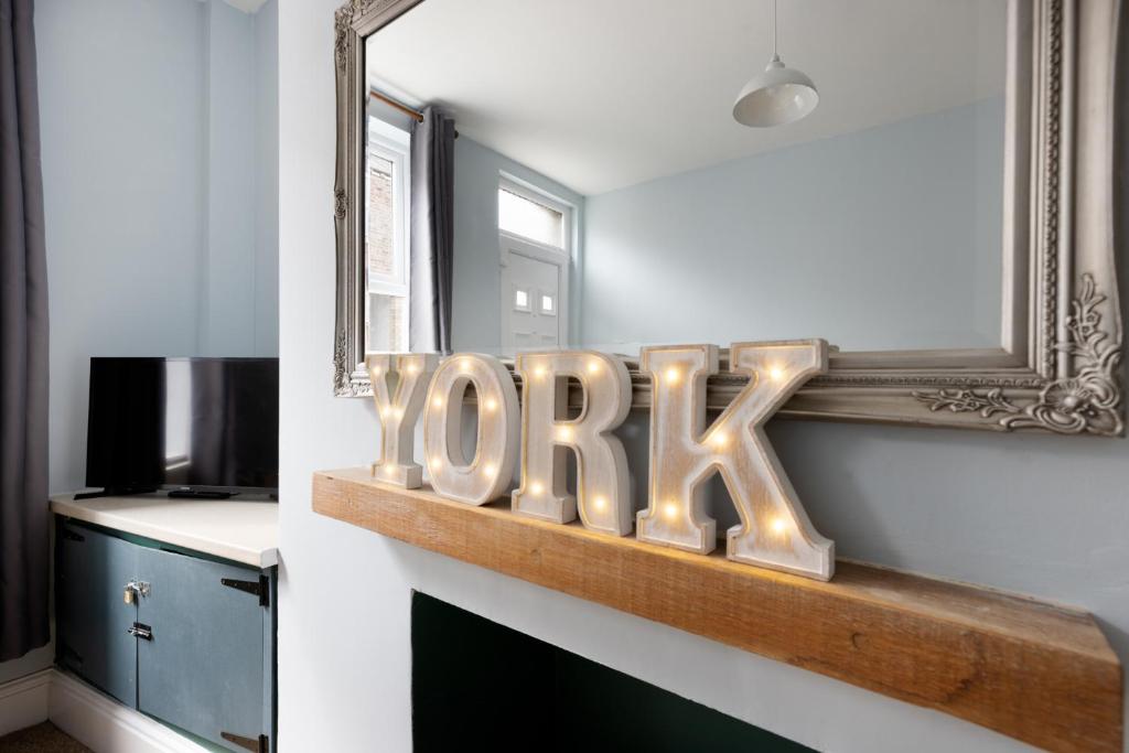 un cartello che dice prega seduto su uno scaffale in una stanza di Ebor Place - Stunning Period Home With Free Parking a York