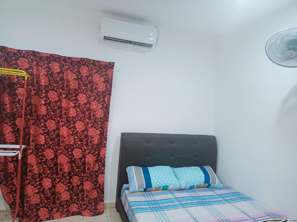a bedroom with a bed with a black headboard and a curtain at Lading Amas Resort in Rengit