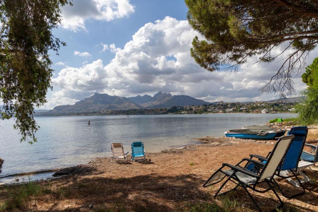 two chairs sitting on the shore of a lake at Casa cancello a mare in Santa Flavia