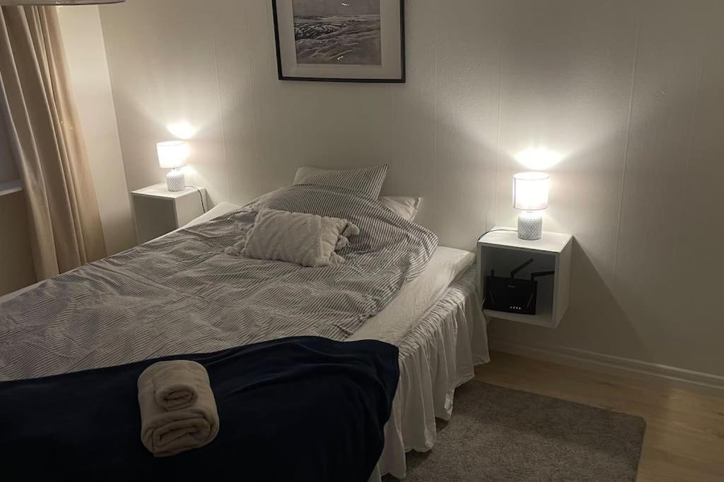 Un dormitorio con una cama con dos lámparas encima. en Mysigt hus nära hav och skog på härliga Alnö, en Släda