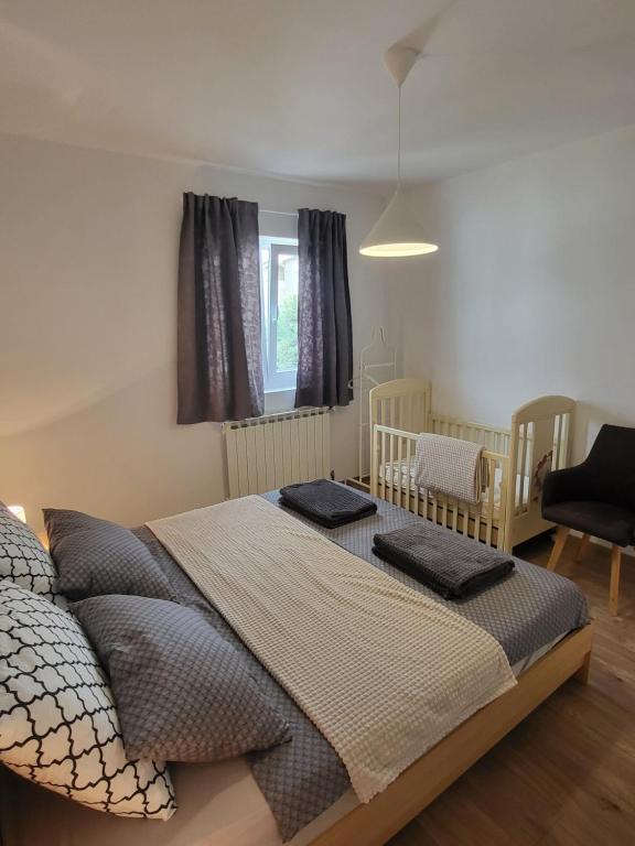 sypialnia z łóżkiem z 2 łóżeczkami dziecięcymi i oknem w obiekcie Apartment Gabrijel w mieście Sveti Filip i Jakov
