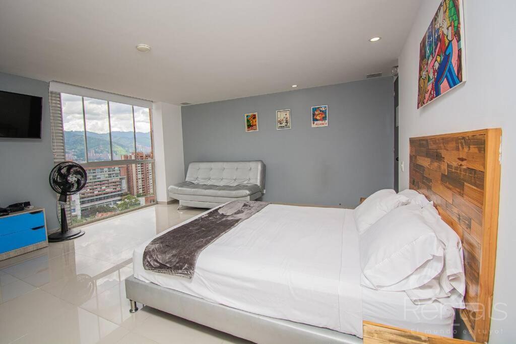 una camera da letto con un letto grande e una televisione di Mountain and City Views Loft Ultra-Fast Internet a Medellín