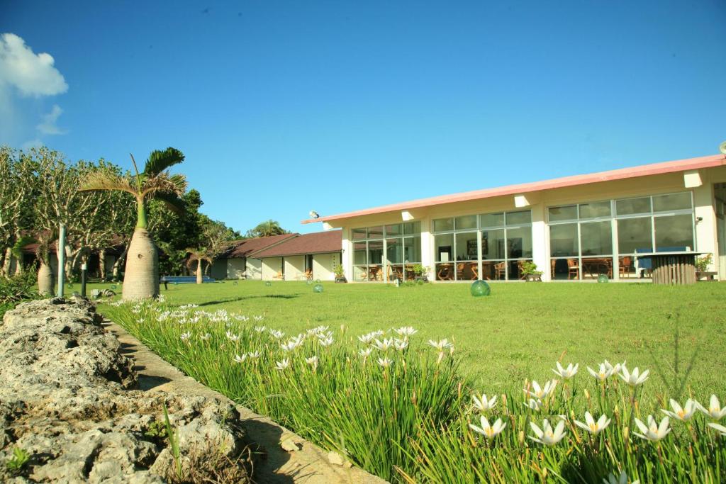 een gebouw met een bloemenveld ervoor bij Villa Unarizaki in Iriomote