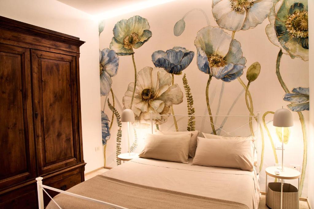a bedroom with a bed with blue flowers on the wall at Dormi da noi in Ancona
