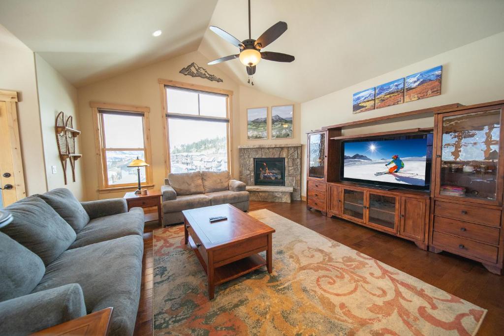 a living room with a couch and a tv at Frey Gulch 46 by SummitCove Lodging in Keystone