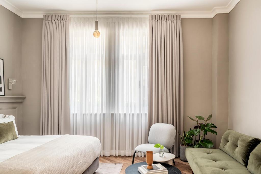 Postel nebo postele na pokoji v ubytování Noel Suites