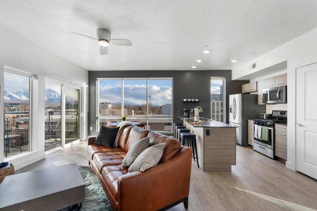 a living room with a brown couch and a kitchen at Spectacular Central City 2BD2BA in Salt Lake City