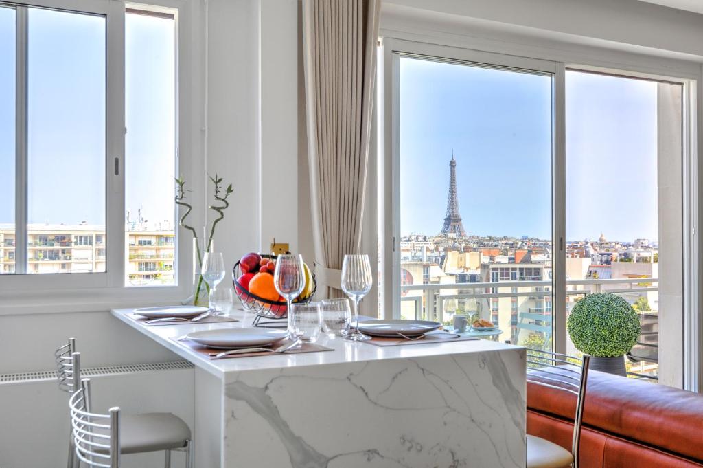 - une salle à manger avec une table et une vue sur la tour Eiffel dans l'établissement 101 Penthouse Royal à Paris avec Vue Imprenable sur la Tour Eiffel, à Paris