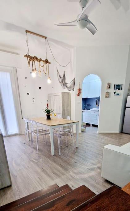 a white dining room with a table and chairs at Ca' MaEle in Cattolica