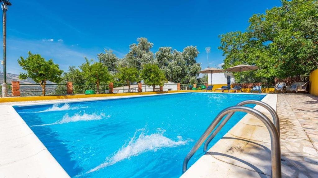 una piscina in un resort con acqua blu di Cortijo el Masegal, Carcabuey, centro de Andalucia a Carcabuey