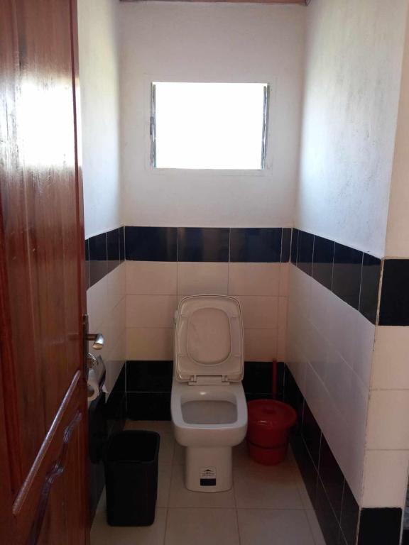 a small bathroom with a toilet and a window at Chez Minerva Ranomafana in Ranomafana