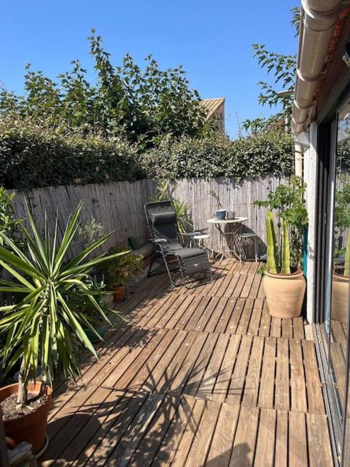 une terrasse avec une chaise, des plantes et une clôture dans l'établissement Maison à 250 m de la plage !, à Sainte-Marie-la-Mer