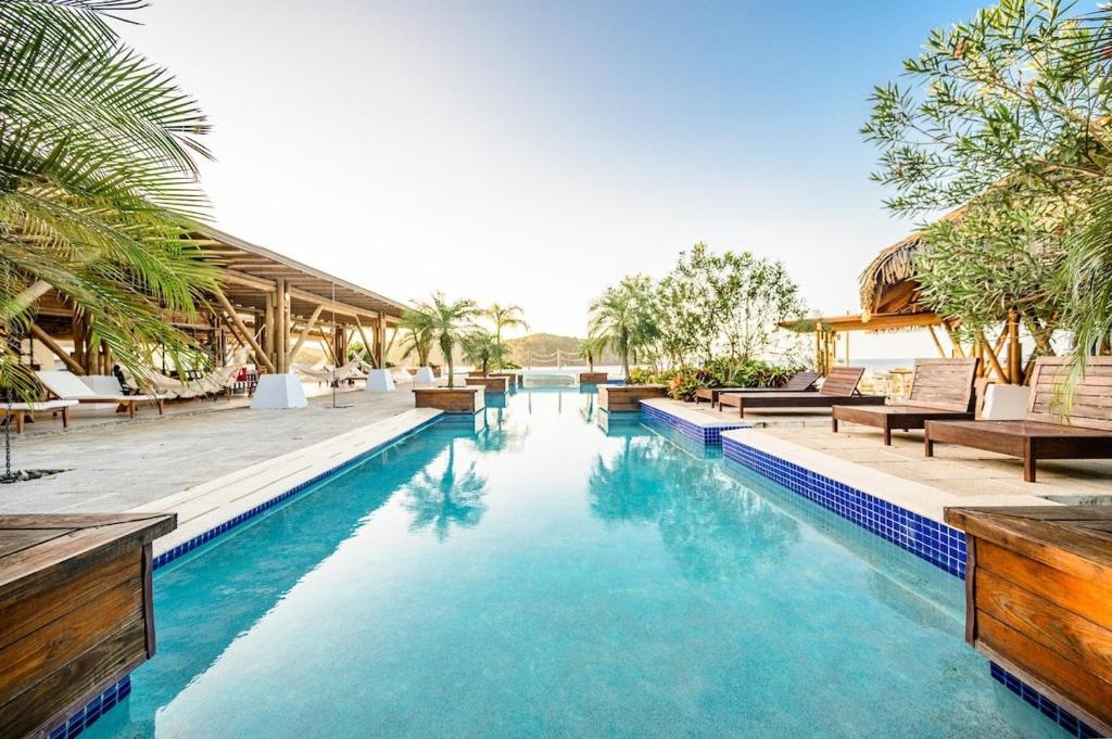 una piscina in un resort con sedie e alberi di Casa Calma Resort Home at Venao a Playa Venao