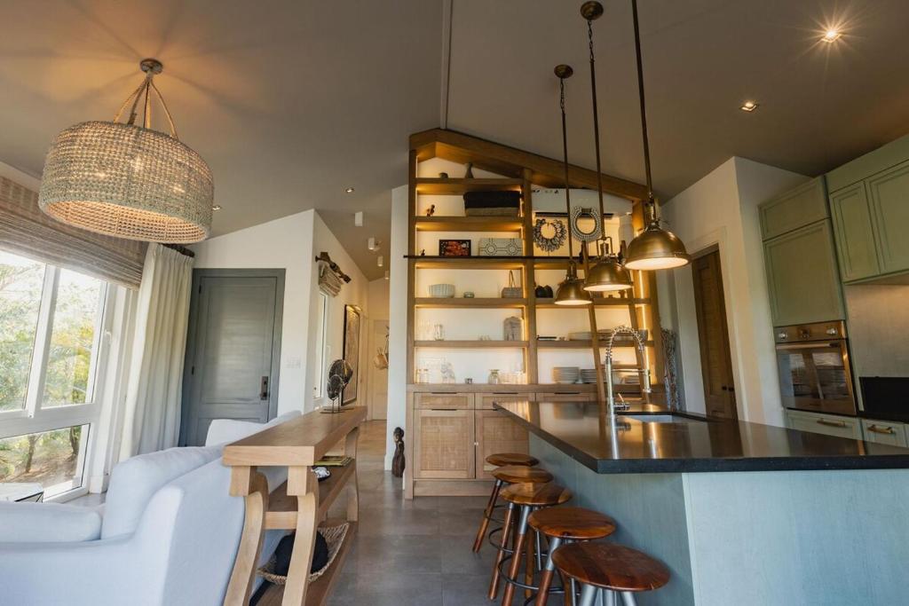 una cucina con bancone e alcuni sgabelli in una stanza di Villa Ceviche Home at the Heart of Venao a Playa Venao
