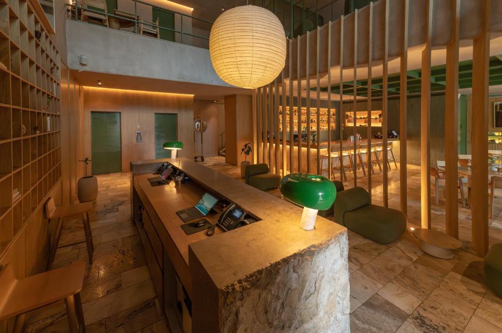 a lobby with a desk with a green lamp at The Charlee Hotel in Medellín