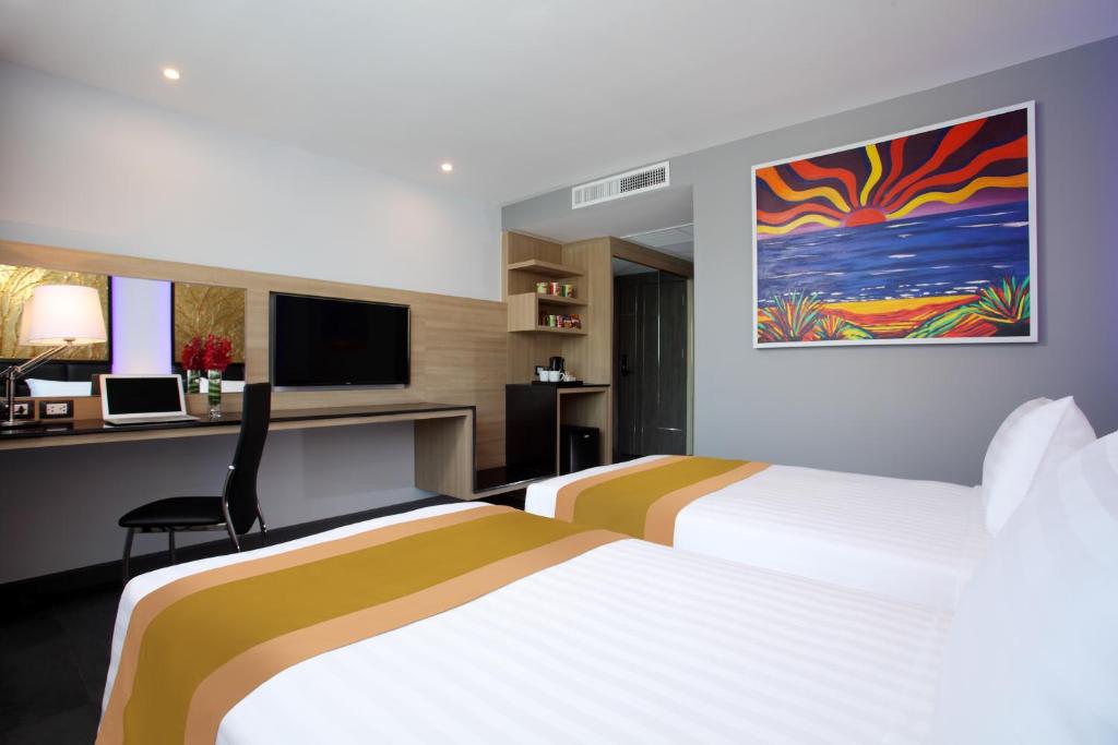 Postel nebo postele na pokoji v ubytování Nova Express Pattaya Hotel