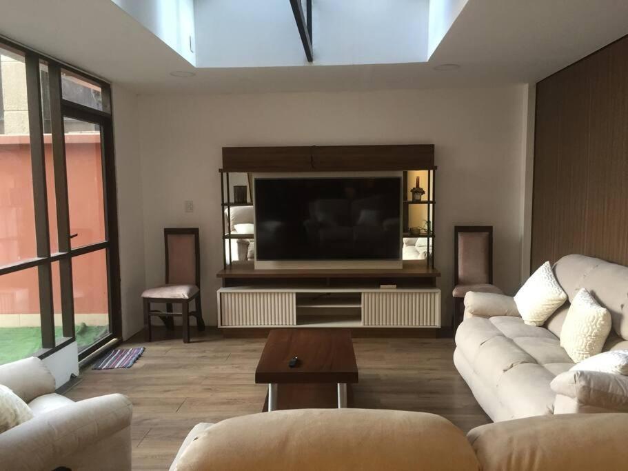 a living room with a couch and a flat screen tv at Departamento céntrico con terrazas y estacionamiento in San Jorge