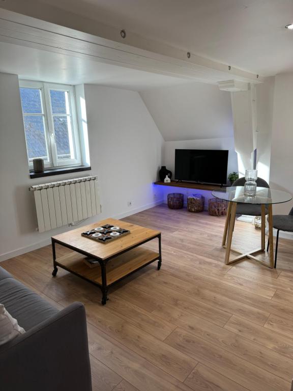 un salon avec une table basse et une télévision dans l'établissement La Suite - Cathédrale, à Chartres