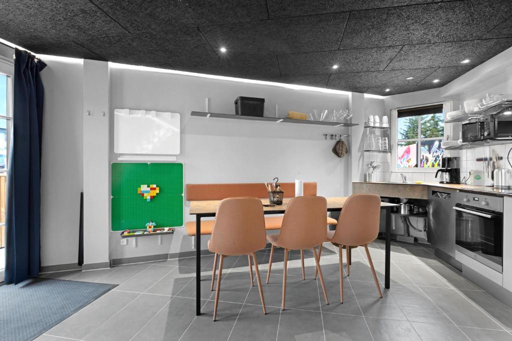a kitchen with a table and chairs in it at Fun Art Holiday Apartment Lots Of Fun For The Whole Family! in Pandrup