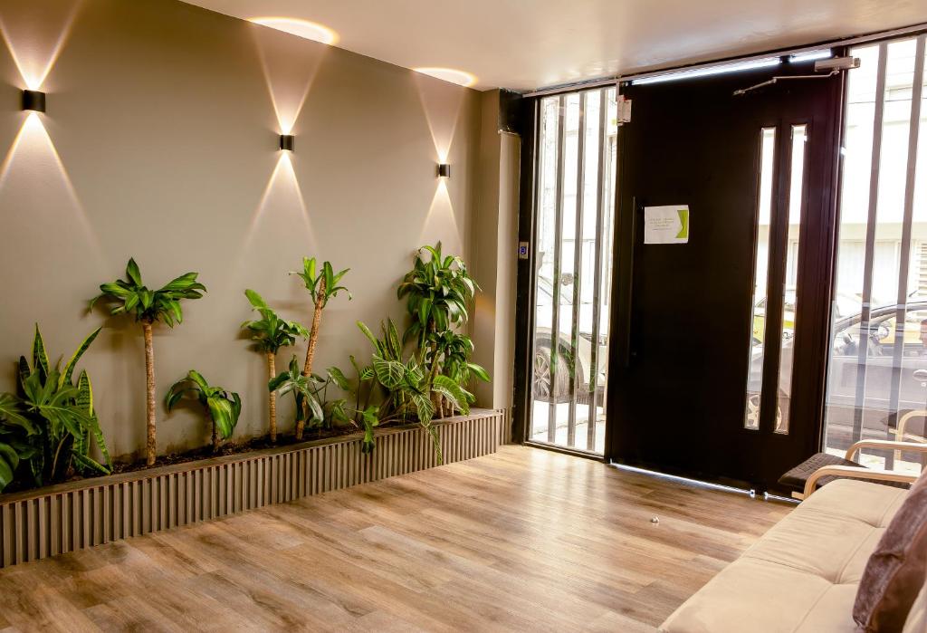 an office lobby with potted plants and a black door at Aerosuites in Bogotá