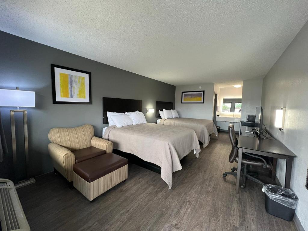 a hotel room with two beds and a desk at Quality Inn Kinder near Casino in Kinder