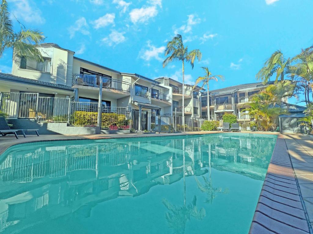 a swimming pool in front of some apartment buildings at Beaches Holiday Resort in Port Macquarie