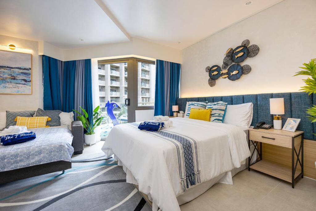 a bedroom with a bed and a couch at Cerulean Bliss Condo at Tambuli Mactan Fast Wifi Netflix in Lapu Lapu City