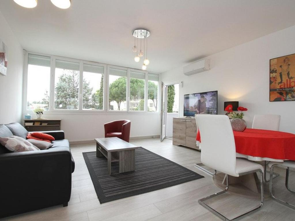 a living room with a couch and a red table at T2 moderne à Balaruc-les-Bains avec clim, parking et wifi - FR-1-553-271 in Balaruc-les-Bains