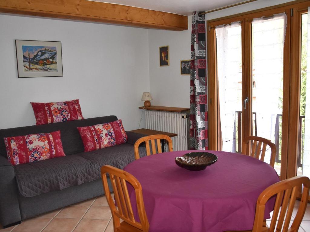 - un salon avec une table violette et un canapé dans l'établissement Appartement 3P à Pralognan-la-Vanoise - Proche commerces - FR-1-464-232, à Pralognan-la-Vanoise