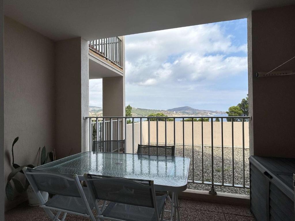 Cette chambre dispose d'un balcon avec une table et des chaises en verre. dans l'établissement Studio cabine climatisé, parking, proche mer à Banyuls, 4 couchages - FR-1-225C-150, à Banyuls-sur-Mer