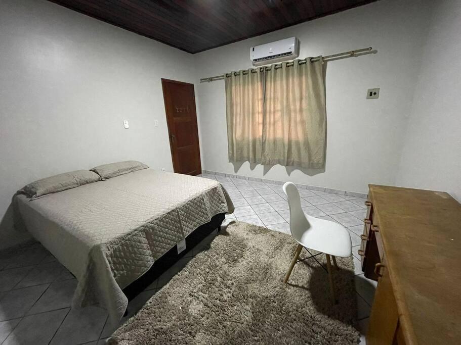 a bedroom with a bed and a desk and a chair at Edícula in Porto Velho