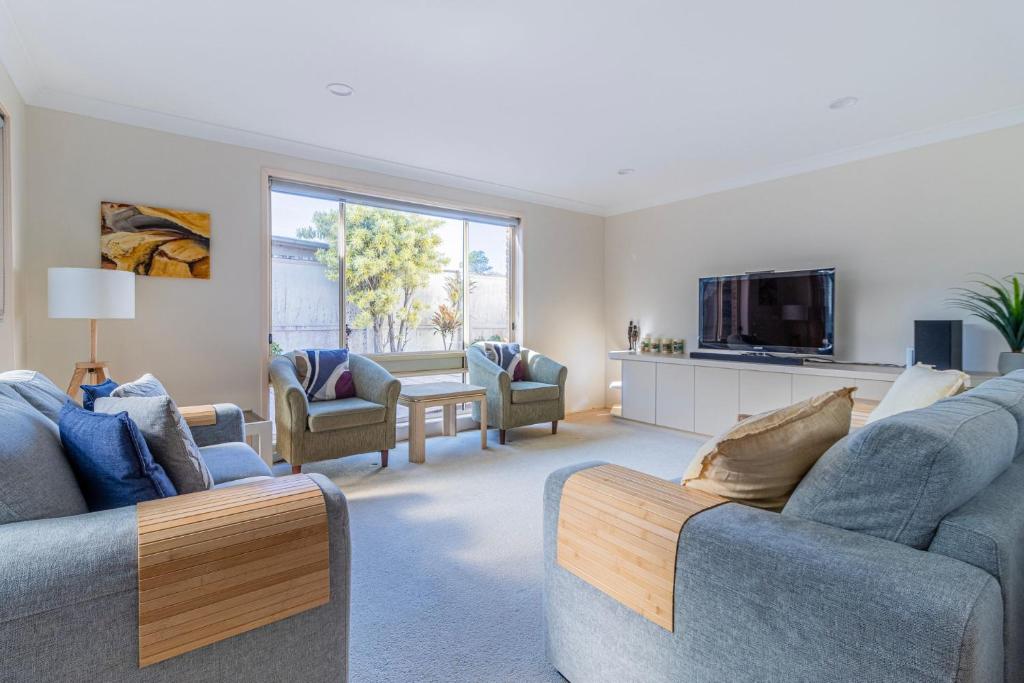 a living room with two couches and a tv at Berrara Breeze in Berrara