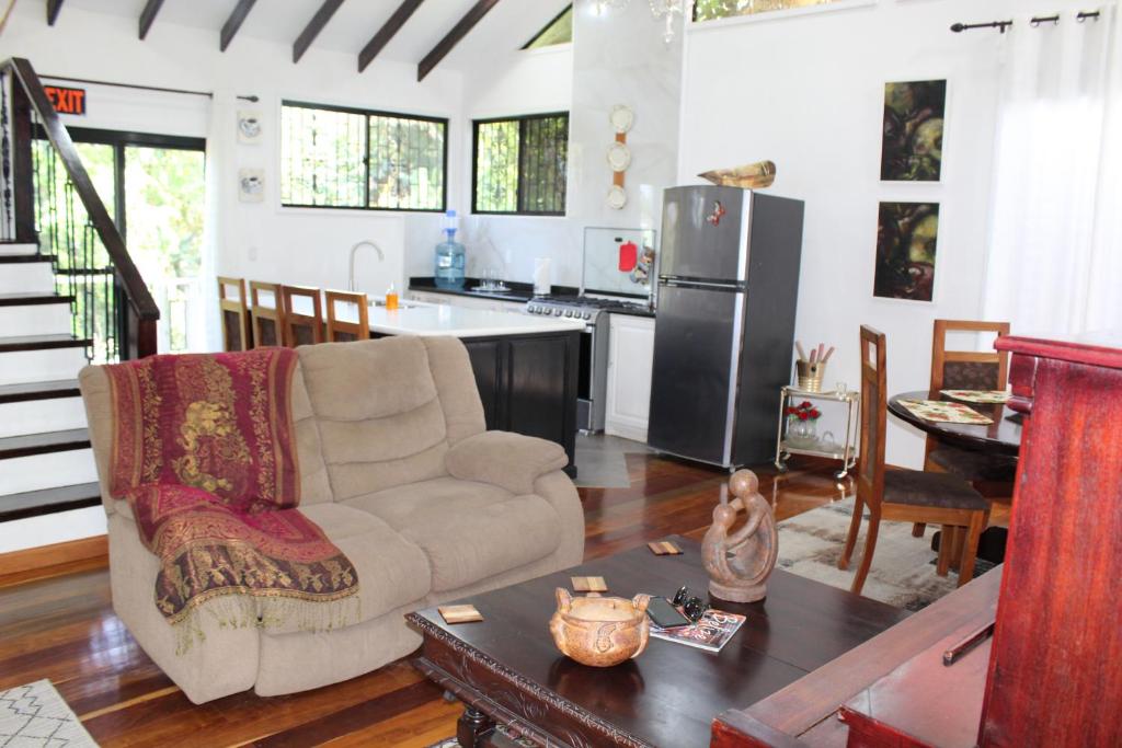 Una sala de estar con un sofá y una cocina. en CAJOMA Villa, en San Ignacio