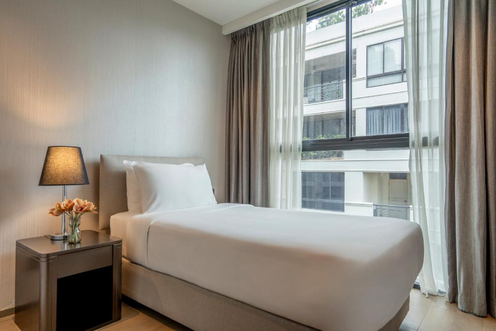 Postel nebo postele na pokoji v ubytování Walton Suites Sukhumvit