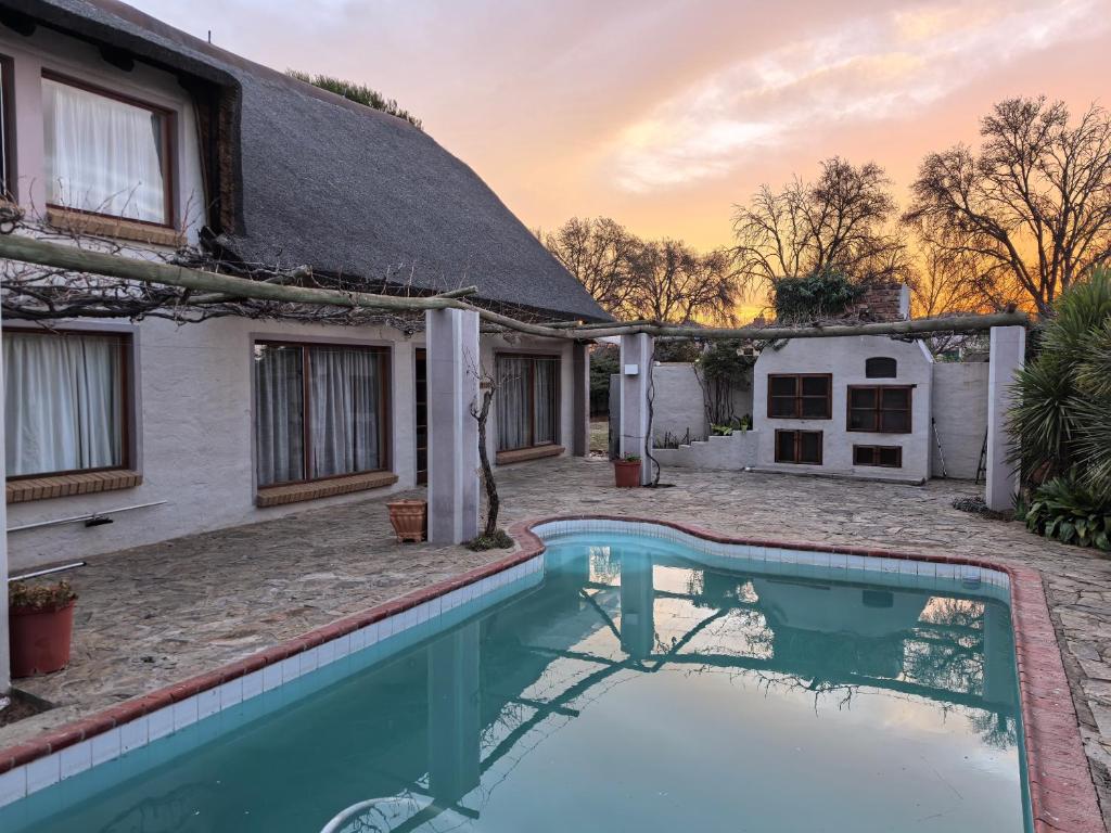 a house with a thatched roof and a swimming pool at Botterblom 1 in Middelburg