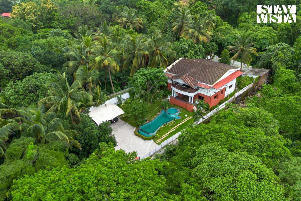 an aerial view of a house in the forest at StayVista at Casa Chalora with Pool, BBQ, Games Room in Candolim
