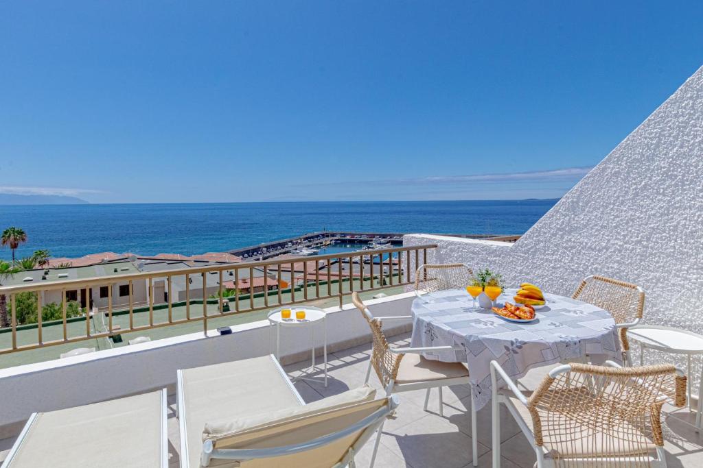 a balcony with a table and chairs and the ocean at Panoramic View Tamara Apt By Dream Homes Tenerife in Acantilado de los Gigantes