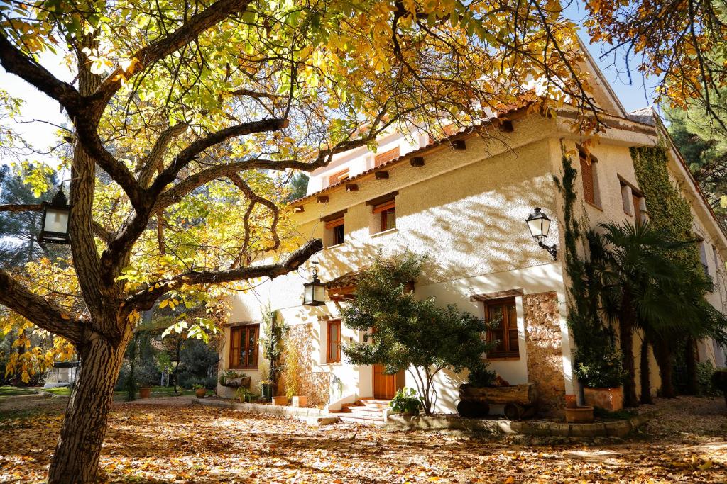 una casa con un árbol delante de ella en Cortijo De Ramón en Cortijos Nuevos