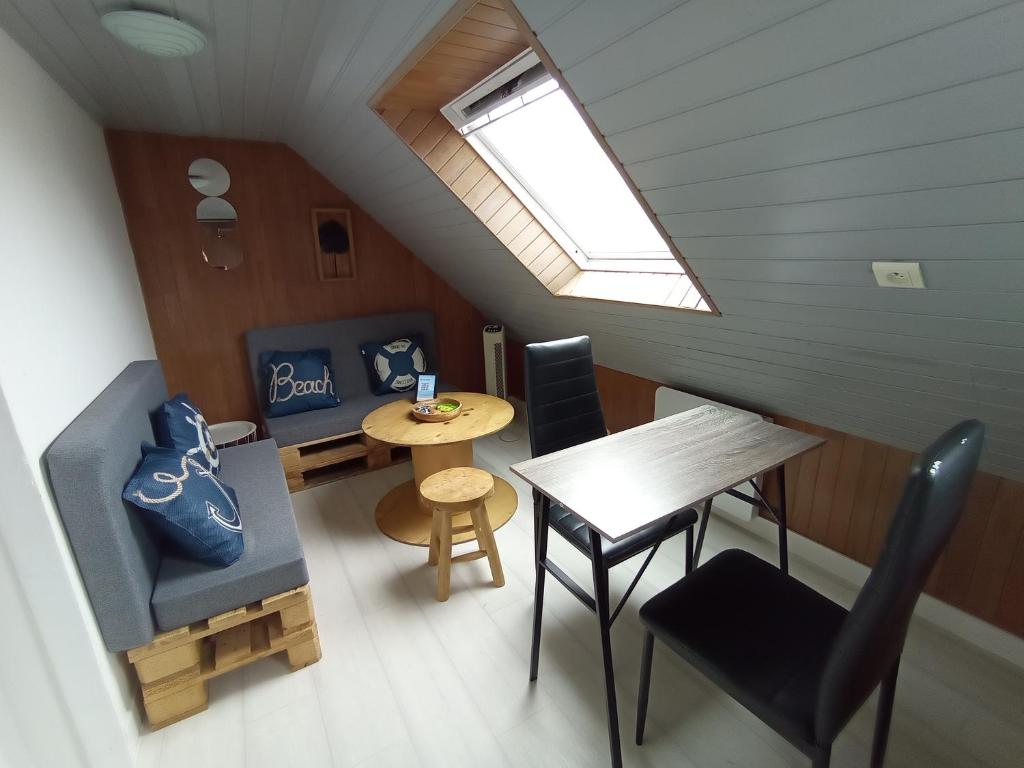 une petite chambre avec une table, des chaises et une fenêtre dans l'établissement Amber- Studio au Passage, à Concarneau