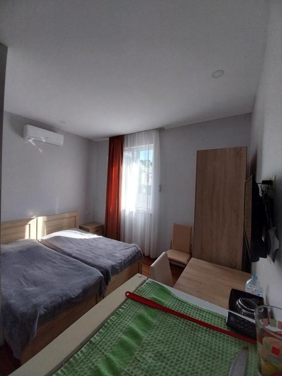 a bedroom with a bed and a table and a window at Sweet studio with all amenities in Batumi