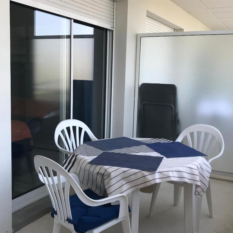 une table et des chaises avec une table bleue et blanche ainsi qu'une fenêtre dans l'établissement Résidence Golf 3 personne, à Ciboure