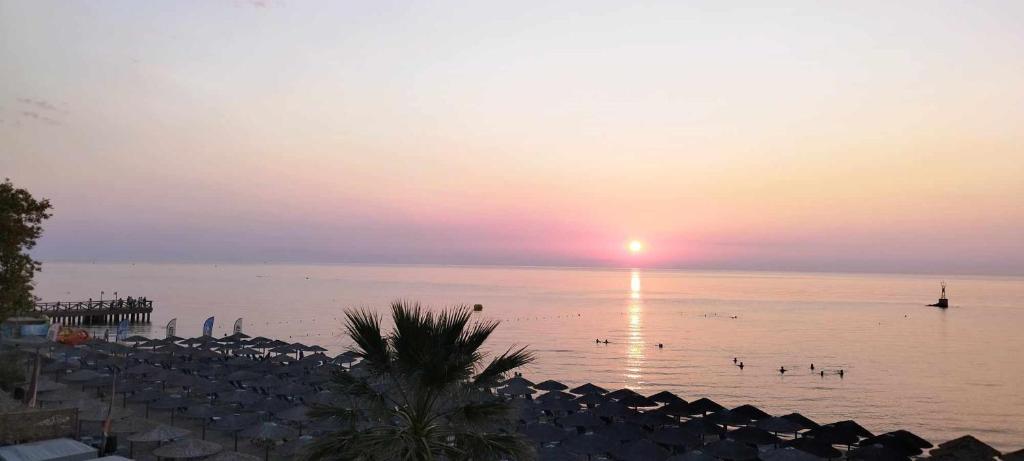 a sunset over a beach with a body of water at Beach Apartment Paralia in Paralia Katerinis